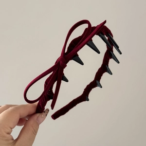 Macro view of burgundy velvet headband featuring a side bow and long non-slip inner teeth
