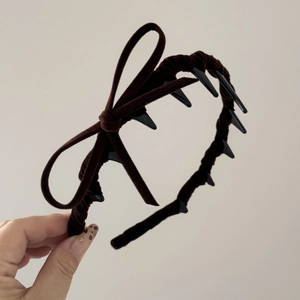 Close-up of brown velvet headband showing anti-slip teeth and side bow detail