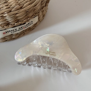 Macro shot of large white iridescent acetate shark hair claw with La France engraving