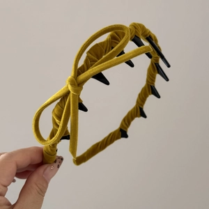 Detail of velvet mustard yellow headband with bow and anti-slip wave teeth grip