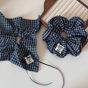 Detail of navy blue plaid hair scrunchie set with pearl accents and bear label