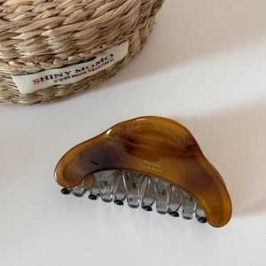 Macro detail of amber resin shark hair claw clip with Barrette La France text engraving