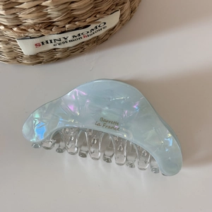 Close-up of iridescent blue acetate hair claw clip with Barrette La France engraving