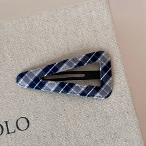 Close-up of blue plaid fabric triangle hair clip with retro BB clip texture