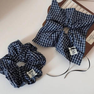 Detailed shot of plaid scrunchie with bear patch, tiny pearl, and black ribbon detail