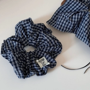 Dark plaid scrunchie with cute bear label and elegant pearl accents on clean white background