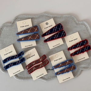 Detail of blue and red plaid fabric hair clips with wave and duckbill metal base