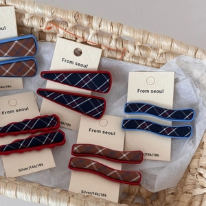 Blue and red plaid fabric hair clips with wave designs in a woven basket arrangement