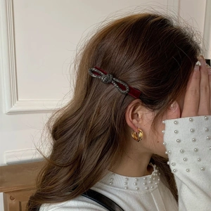 Elegante fermaglio per capelli in velluto rosso con fiocco di strass su una modella