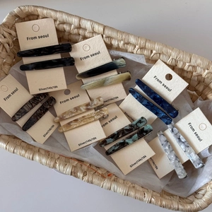 Lot de deux barrettes vintage en acétate avec motifs marbrés dans un panier