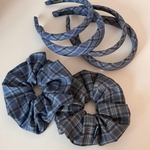 Detail view of blue plaid fabric scrunchies and headbands set with a classic woven pattern