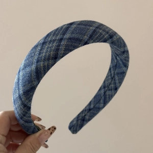 Detail of thick denim blue checkered headband with premium pleated fabric texture