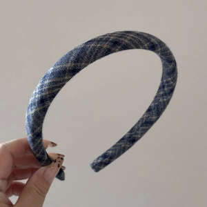 Close-up of retro navy and beige plaid fabric headband with classic tartan pattern