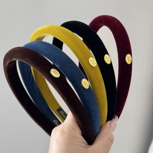 Detail of colorful velvet headbands with golden SMILE HAPPY metal label and soft texture