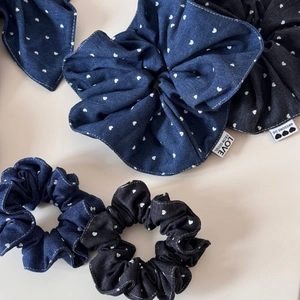 Detail of denim hair scrunchies with white heart patterns and fine stitching texture