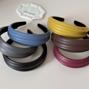 Detailed view of wide-brimmed PU leather headbands with textured ribbing in six colors