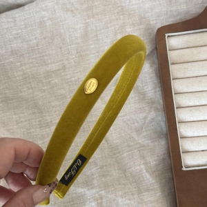 Close-up of mustard yellow velvet headband with gold SMILE HAPPY metal buckle detail