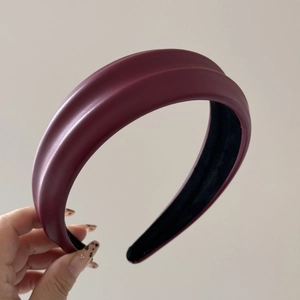 Detail view of wine red PU leather headband with thick sponge and black non-slip velvet lining
