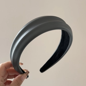 Macro detail of dark grey PU leather headband with textured surface and sponge padding