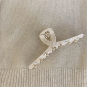 Detail shot of large cream acetate hair claw clip with rectangle crystal rhinestones