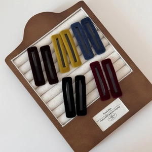 Vintage rectangle velvet hair clips set in diverse colors on a wooden display tray