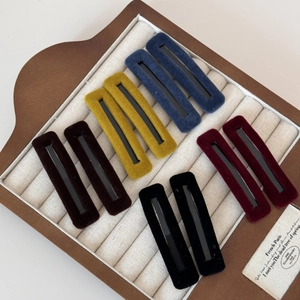 Set of 10 rectangular velvet hair clips in five vintage colors on a jewelry display