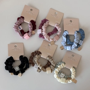 Détail de chouchous colorés avec perles géométriques et pendentifs dorés en gros plan
