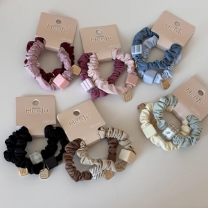 Détail d'élastiques à cheveux colorés avec breloques carrées sur cartes de présentation
