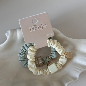 Détail d'élastiques à cheveux avec breloques carrées en vert pastel et beige doux