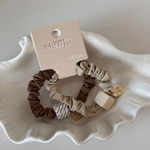Détails de deux élastiques à cheveux avec cubes géométriques et pendentif doré