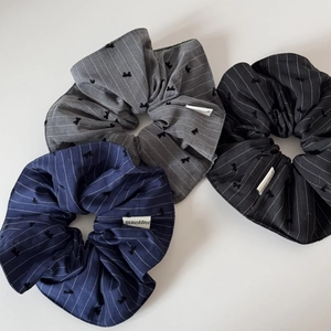 Detailed view of striped hair scrunchies with bow embroidery and Happiness label