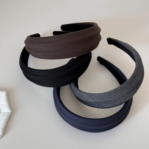 Detailed close-up of four ribbed fabric headbands in black, coffee, grey, and navy colors