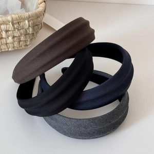 Macro detail of ribbed fabric headbands in brown, black, navy blue and dark grey colors
