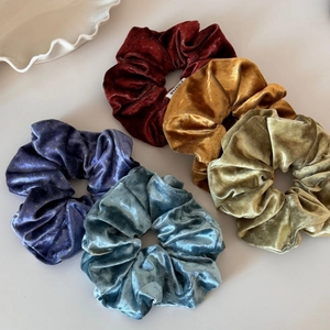 Detail of five velvet scrunchies in Morandi colors with delicate polka dot patterns
