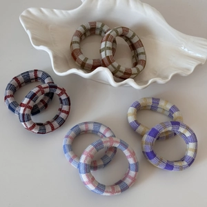 Détail d'élastiques à cheveux à carreaux sans couture en quatre combinaisons de couleurs