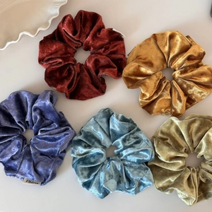 Detailed view of five velvet polka dot scrunchies in assorted premium fall colors