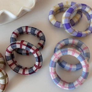 Élastiques à cheveux en maille à carreaux multicolores sur un fond blanc épuré