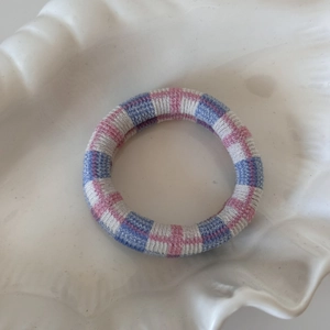 Vue détaillée d'un chouchou tricoté à carreaux sans couture sur une coupelle blanche