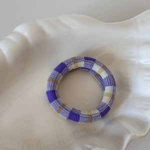 Gros plan du motif à carreaux violet et blanc sur le chouchou élastique sans couture