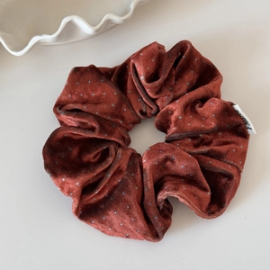 Detail of reddish-brown velvet scrunchie with blue polka dots and a MARU label