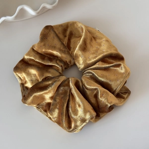 Close-up of velvet polka dot scrunchie in bronze with detailed texture and glossy finish