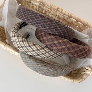 Retro plaid sponge headbands in various colors placed in a rustic woven basket