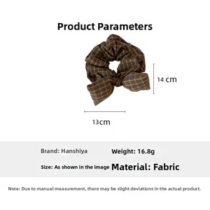 Detailed view of a brown plaid bow scrunchie with 13cm x 14cm size dimensions shown