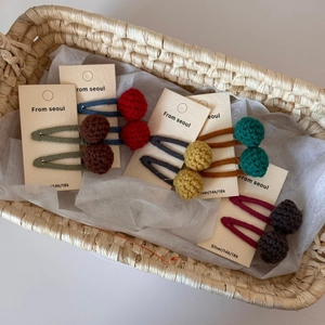 Close-up of colorful handmade knit pom-pom hair clips for girls on display cards