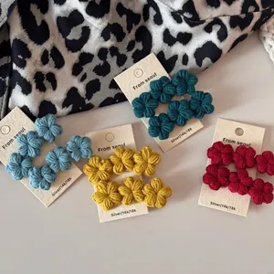 Handmade crochet flower studs in vibrant colors displayed on a minimalist jewelry card