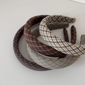 Detailed texture of thick plaid and houndstooth fabric headbands in neutral colors