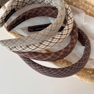 Detailed view of handmade plaid headbands with cotton texture in a woven basket