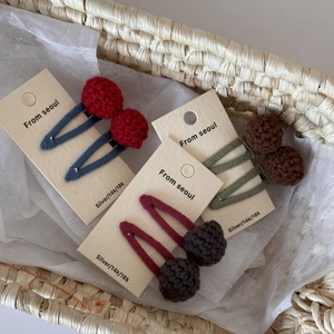 Three pairs of colorful handmade knit ball BB hair clips for girls in a woven basket