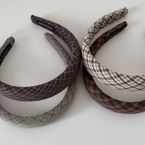 Detail of four plaid padded headbands with handmade tags in assorted neutral colors