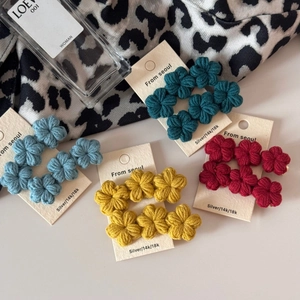 Detailed macro view of handmade crochet flower hair clips in four gradient vintage colors